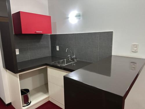 a kitchen with a sink and a red cabinet at Hotel Nuevo Mundo in San Rafael