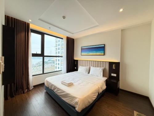 En eller flere senge i et værelse på Sapphire Hạ Long Aurora Apartment
