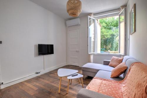 un salon avec un canapé et une télévision dans l'établissement L'échappée verte, à Périgueux