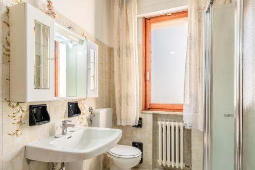 een badkamer met een wastafel en een toilet en een raam bij Casa nella campagna Toscana in Lazzeretto