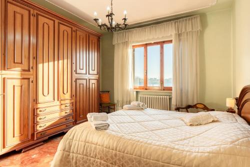 een slaapkamer met een groot bed en een raam bij Casa nella campagna Toscana in Lazzeretto