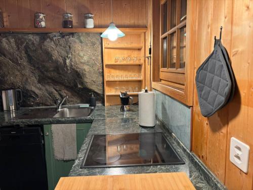 een keuken met een spoelbak en een aanrechtblad bij Chalet Les Epilobes, Zinal in Zinal