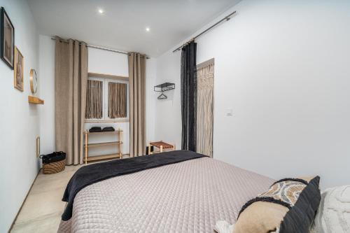 een slaapkamer met een bed en een raam bij Algarvia in Parchal