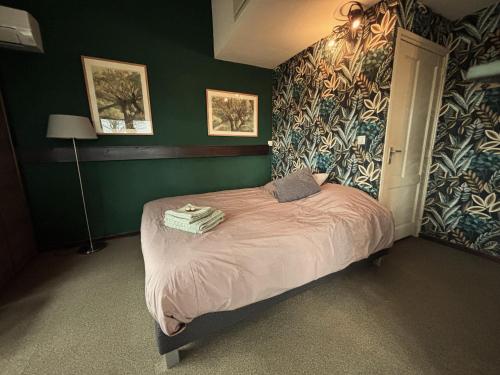 una camera da letto con un letto in una stanza con pareti verdi di Gastenhuisje De Donk a Brandwijk