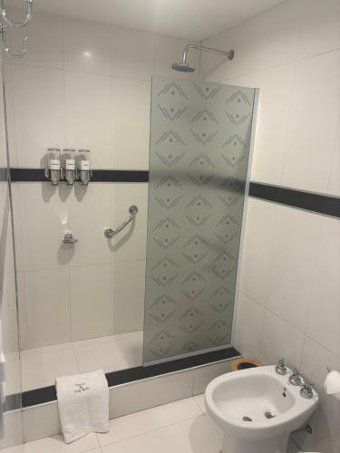 a bathroom with a shower and a toilet and a sink at Patios de City Bell Hotel and Apartments in City Bell
