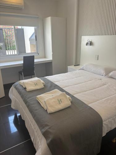 a hotel room with two beds with towels on them at Patios de City Bell Hotel and Apartments in City Bell