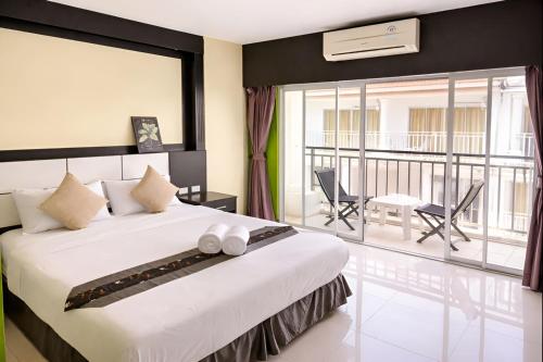 een slaapkamer met een groot bed en een balkon bij The Star House in Patong Beach