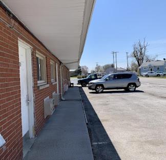 a car parked in a parking lot next to a brick building at Express Motel in Northwood