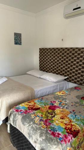 two beds sitting next to each other in a room at Pousada por do sol in Monte das Gameleiras