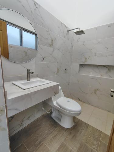 een badkamer met een toilet, een wastafel en een spiegel bij CASA VILLA NICA Nariño Cundinamarca in Nariño
