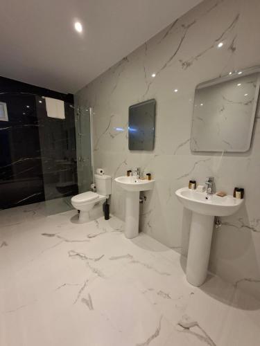 ein weißes Badezimmer mit zwei Waschbecken und einer Toilette in der Unterkunft Twin Beds Standard Studios by Kentrikon 1924 Hotel, Old Town in Paphos City