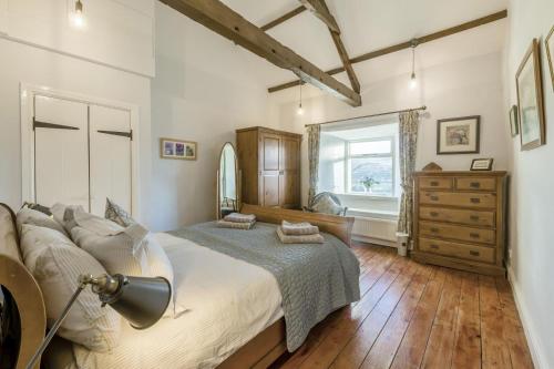 ein Schlafzimmer mit einem Bett, einer Kommode und einem Fenster in der Unterkunft 3 Bed in Low Row oc-h34097 in Gunnerside