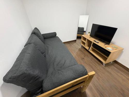 een woonkamer met een grijze bank en een tv bij Karü in Aluminé