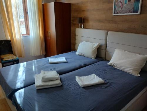 un lit bleu avec deux serviettes blanches dessus dans l'établissement Paradise, à Bourgas