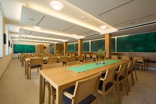 ein Klassenzimmer mit Holztischen und -stühlen und einer grünen Tafel in der Unterkunft Burkardushaus, Tagungszentrum am Dom in Würzburg