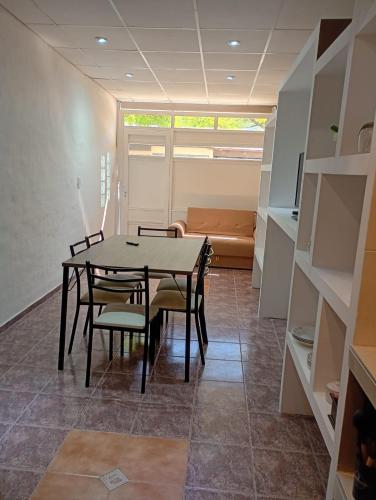 una sala da pranzo con tavolo, sedie e divano di Alojamiento Gral Alvear a General Alvear
