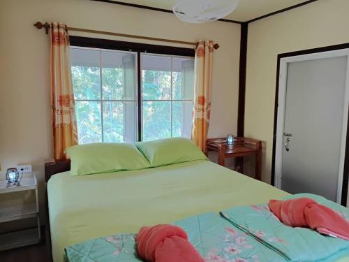 een slaapkamer met een bed en een groot raam bij Koh Kood Little Hut in Ko Kood