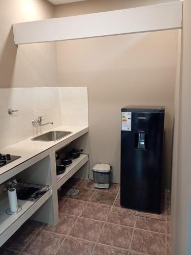 a kitchen with a black refrigerator and a sink at Alojamiento Gral Alvear in General Alvear