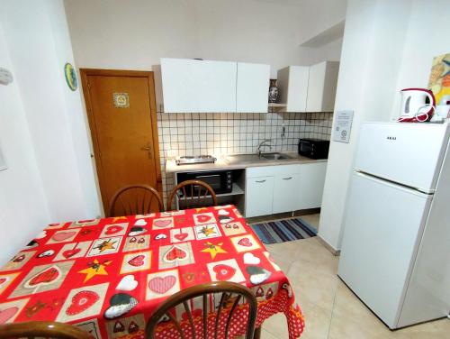 een keuken met een tafel en een witte koelkast bij La Casa Di Via Marzulli in Acireale