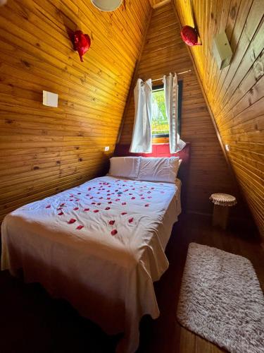 a bedroom with a bed in a wooden room at Chalé Aconchego Alfredo Wagner in Alfredo Wagner