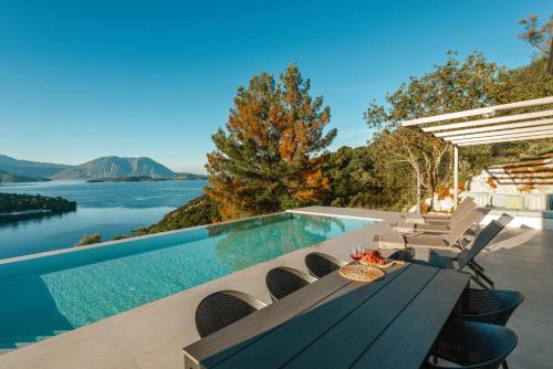 a house with a swimming pool and a table and chairs at Kohyli Villas in Meganisi