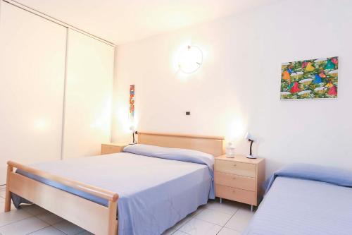 a bedroom with two beds and a clock on the wall at Il Porto trilocale nr.7 in Porto Azzurro