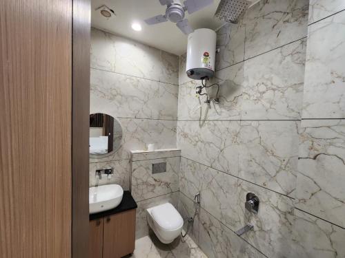 a bathroom with a white toilet and a sink at Den Inn in Hisār