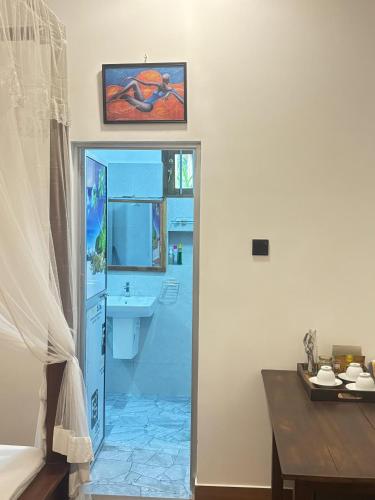 a room with a bathroom with a sink and a doorway at Sunset view Beach villa in Tangalle