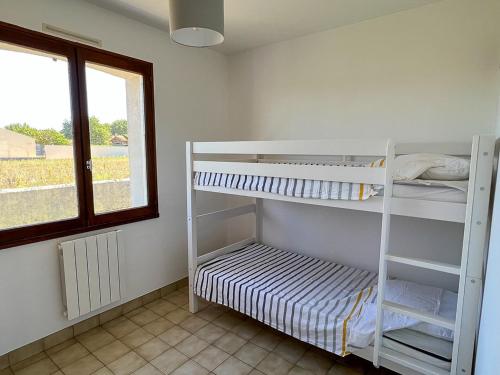 ein Zimmer mit zwei Etagenbetten und einem Fenster in der Unterkunft Résidence du Moulin Girard in Jard-sur-Mer