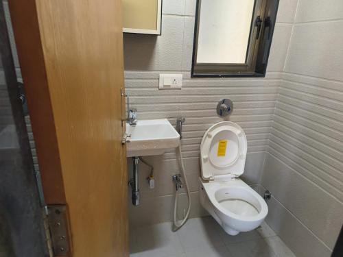 a small bathroom with a toilet and a sink at Riyas stay in Mumbai
