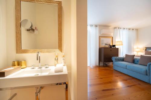 a bathroom with a sink and a blue couch at Once Upon Lisboa in Lisbon