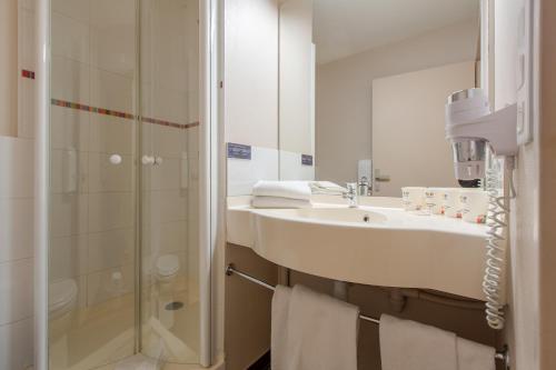 een badkamer met een wastafel en een douche bij Ace Hotel Riom in Riom