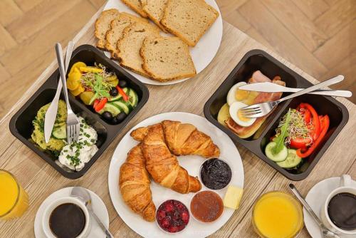 a table with three trays of breakfast food on it at Blue Sky - Apartamenty Premium Zator in Zator