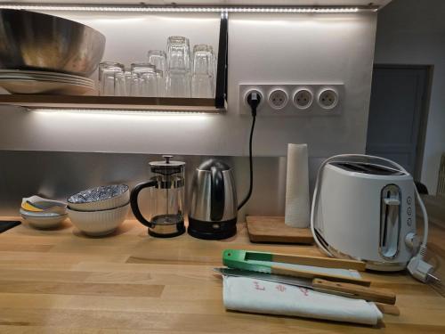 eine Küchentheke mit einem Toaster und anderen Küchenutensilien in der Unterkunft Studio 2 personnes proche du Futuroscope in Beaumont
