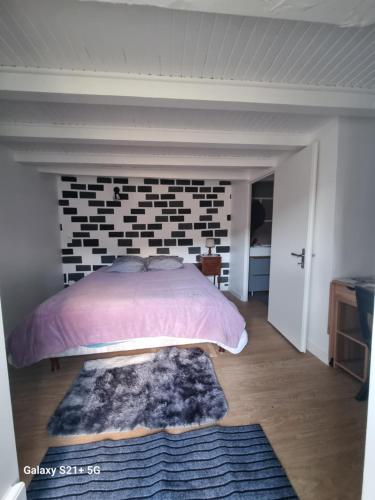 een slaapkamer met een bed en een bakstenen muur bij Chez Marilou in Arcens