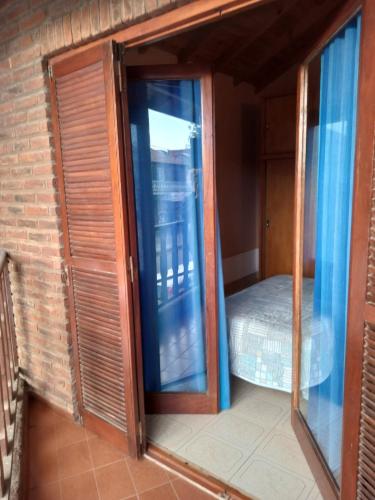 a room with a glass door and a bed at Arevalo Mar de Ajo in Mar de Ajó