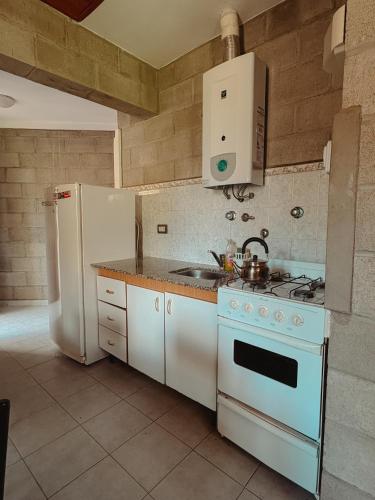 a kitchen with a white stove and a refrigerator at Complejo La Yema in Miramar