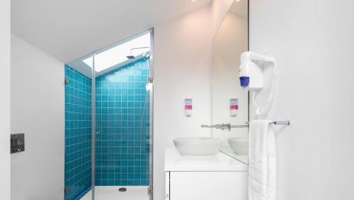 a bathroom with a shower with blue tile at Lisbon Serviced Apartments - Parque in Lisbon