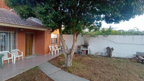 een boom in een tuin naast een huis bij Arevalo Mar de Ajo in Mar de Ajó