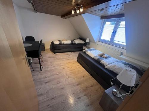 ein Zimmer mit zwei Betten und einem Tisch darin in der Unterkunft Team at Home Gemütliches Dachgeschossapartment in Blaubeuren