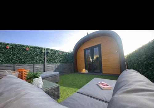 a small backyard with a patio with grass and a building at Willow Nook, near Saundersfoot and Tenby in Saundersfoot