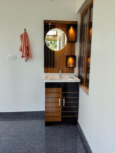 a bathroom with a sink and a mirror at VLand homestay in Vagamon