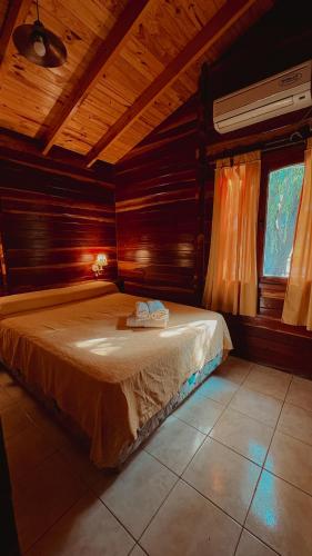 a bedroom with a bed in a wooden room at Complejo La Yema in Miramar