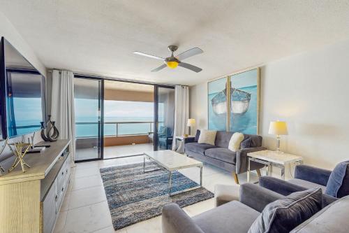 a living room with a couch and a ceiling fan at Crescent Beach Club I 12D in Clearwater Beach