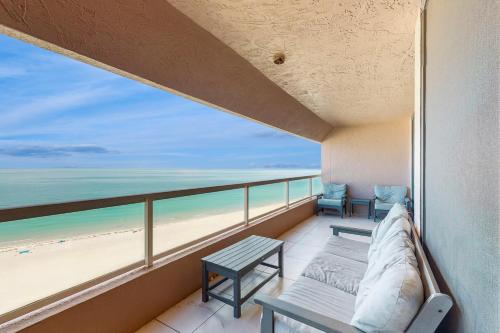 a balcony with two chairs and a view of the beach at Crescent Beach Club I 12D in Clearwater Beach