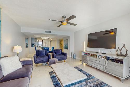 a living room with a large flat screen tv at Crescent Beach Club I 12D in Clearwater Beach