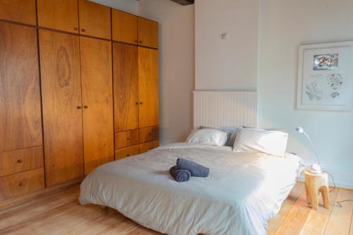 a bedroom with a large white bed with wooden cabinets at De Wijngaard in Ghent