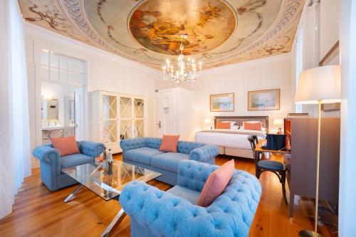 a living room with blue couches and a bedroom at Once Upon Lisboa in Lisbon