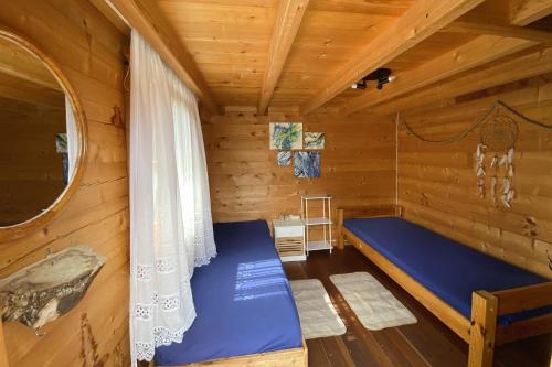 a room with a blue bed in a wooden cabin at Blockhütte am Flugplatz mit Pool in Kühndorf