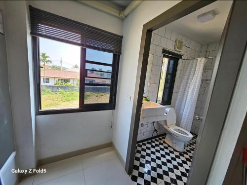 a bathroom with a toilet and a sink and a window at ชวนไดอารี่ Chuan Diary in Ban Nong Bua